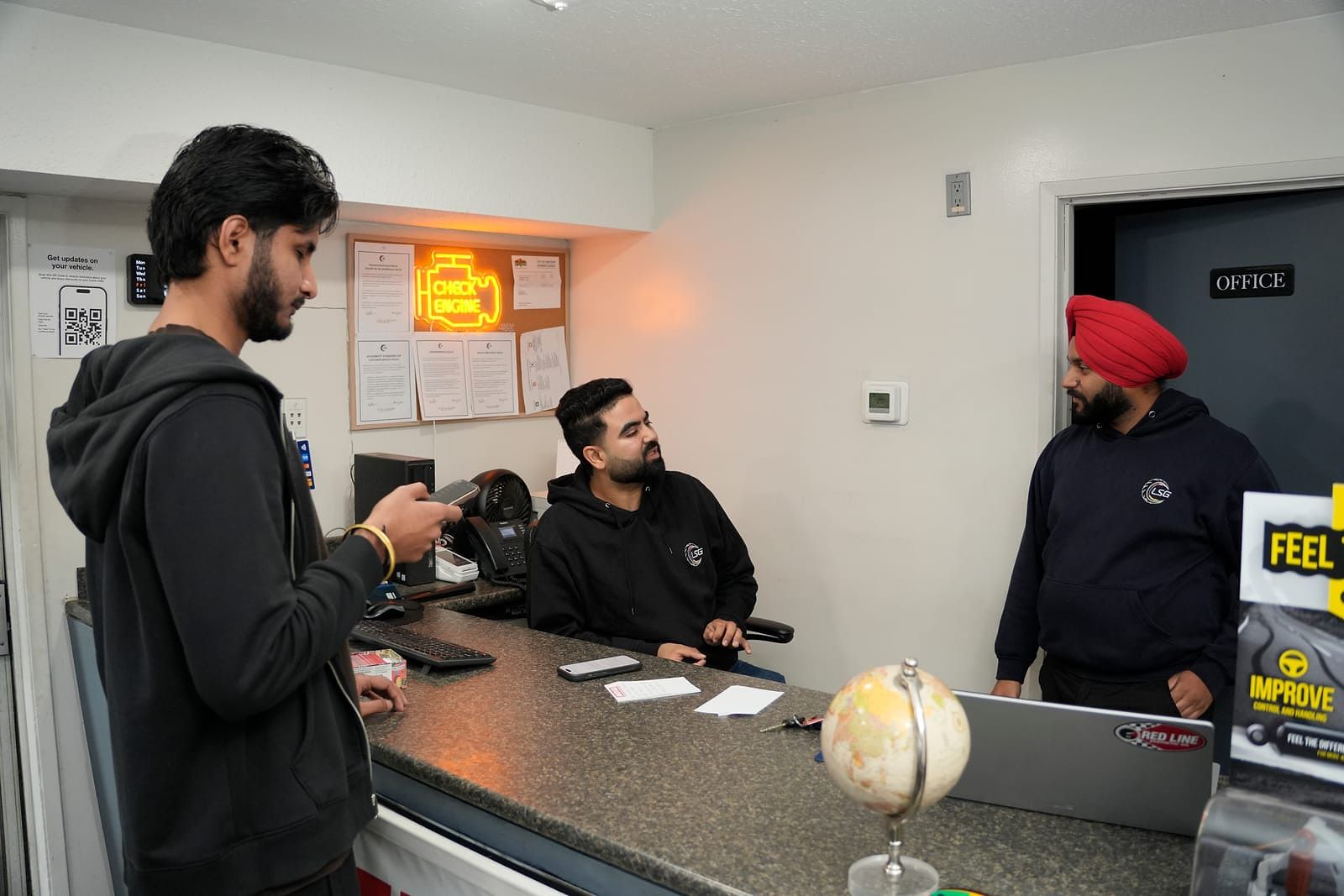 A customer talking with LSG Auto Nation staff at the front counter
