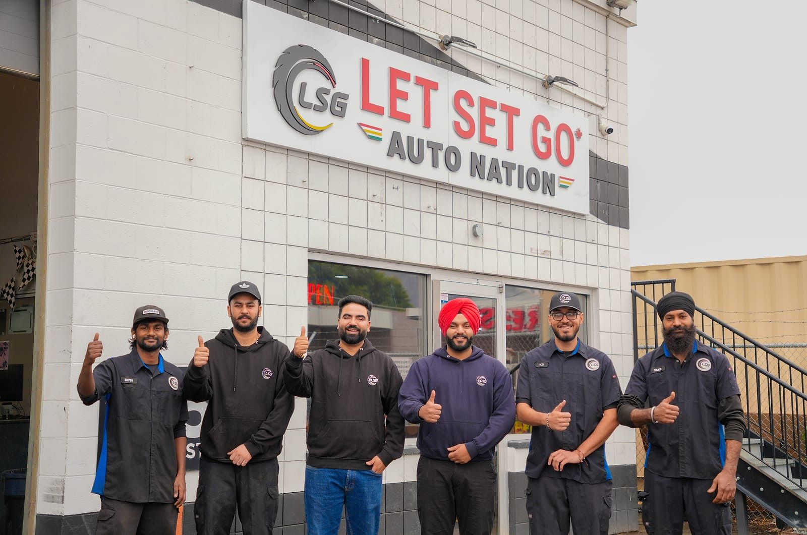 The LSG Auto Nation team giving a thumbs up outside the shop